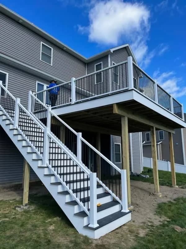 Elevated deck construction with white railings and wooden support