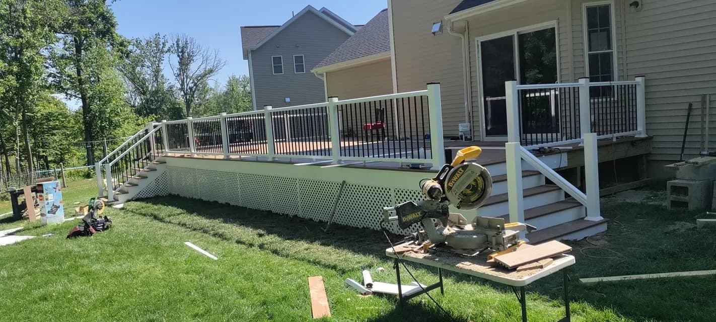 Deck installation in progress with miter saw on lawn