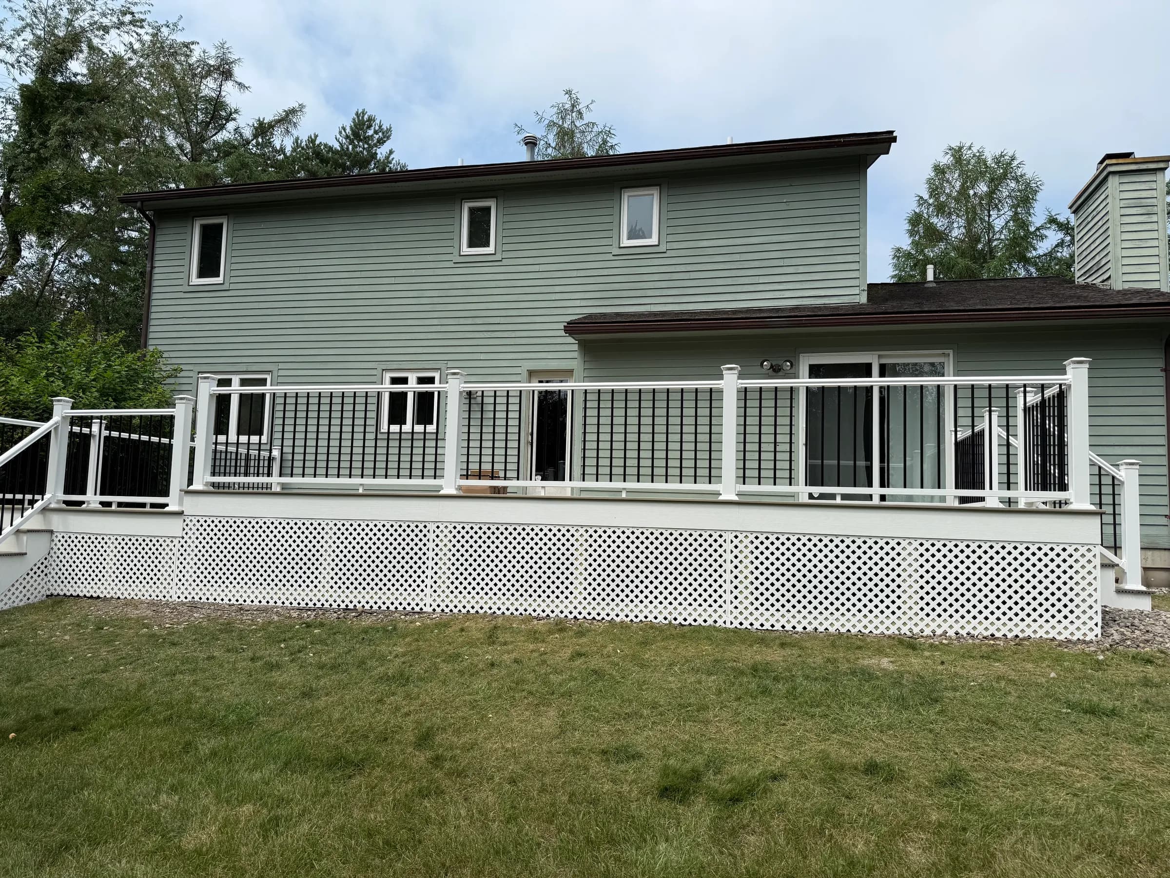 Backyard deck with black railings and white lattice