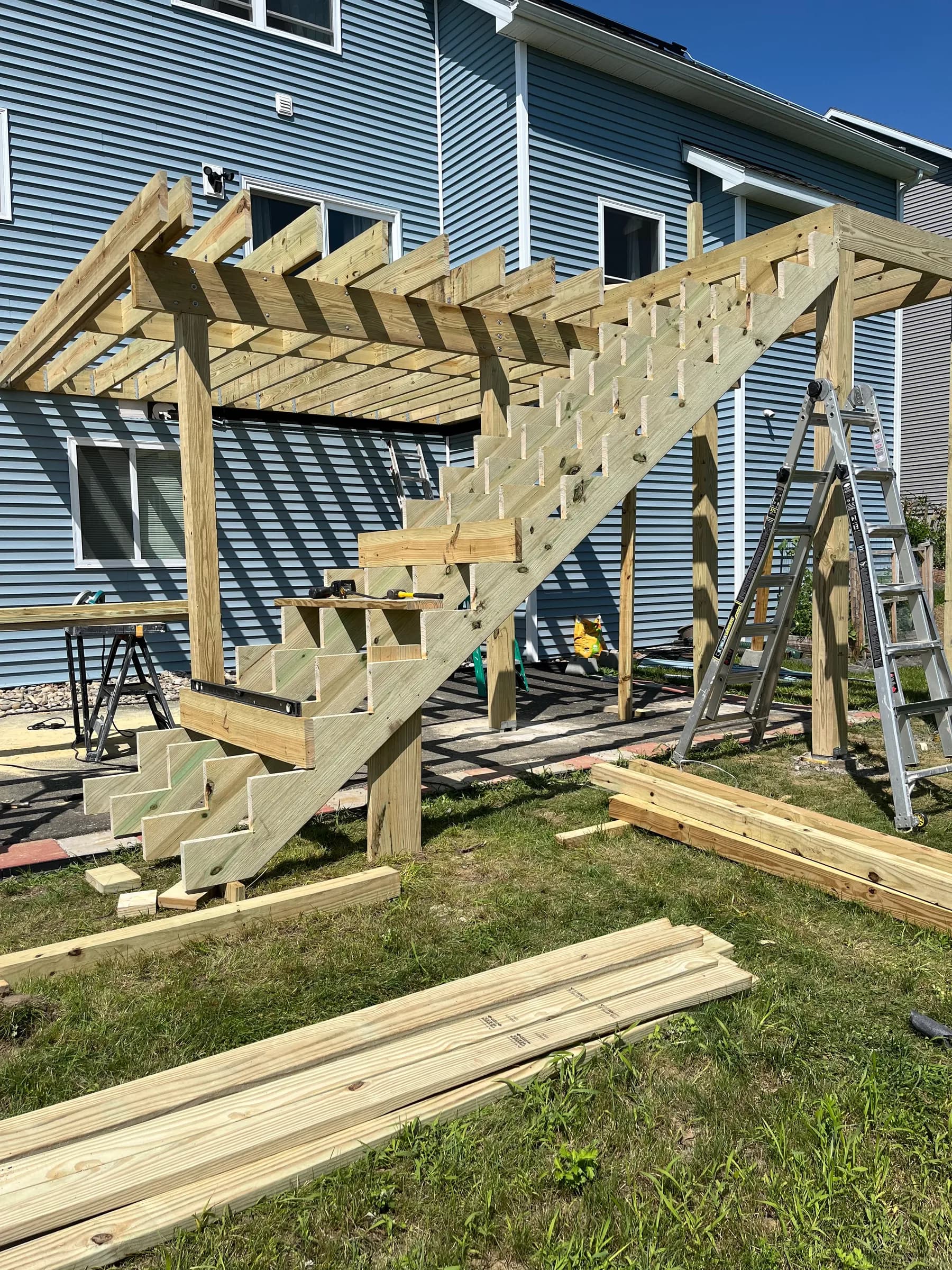 Wooden pergola beams over metal roof and deck