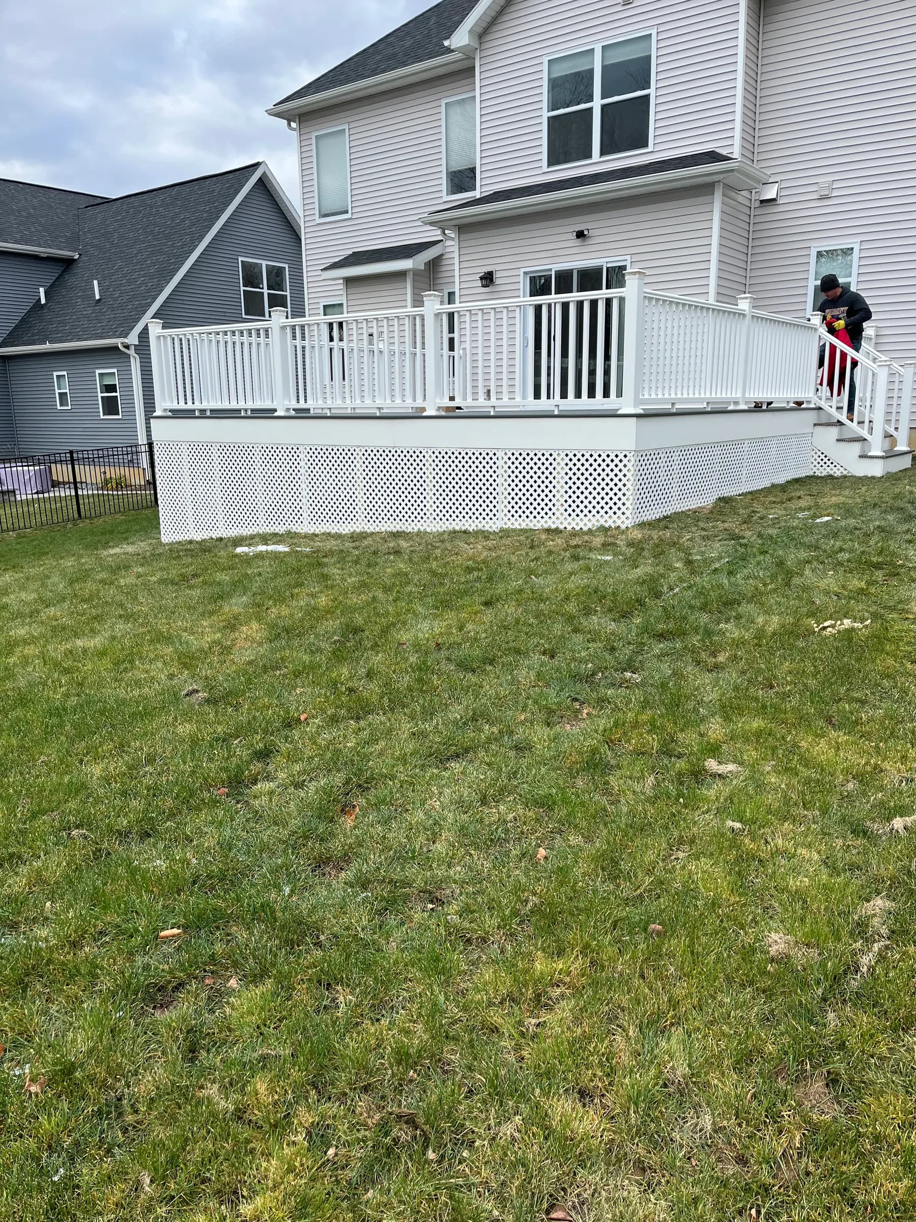 White elevated deck with stairs viewed from lawn