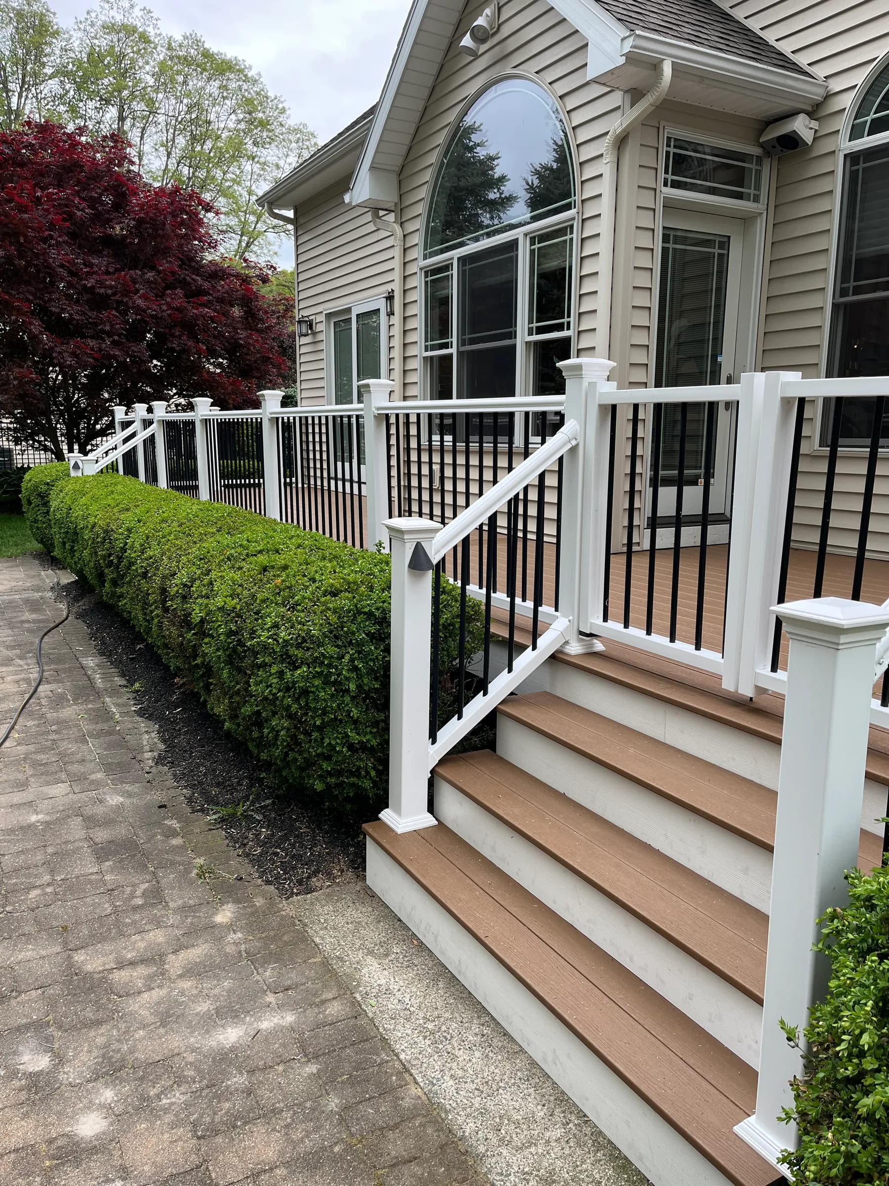 White vinyl porch on home with manicured landscaping