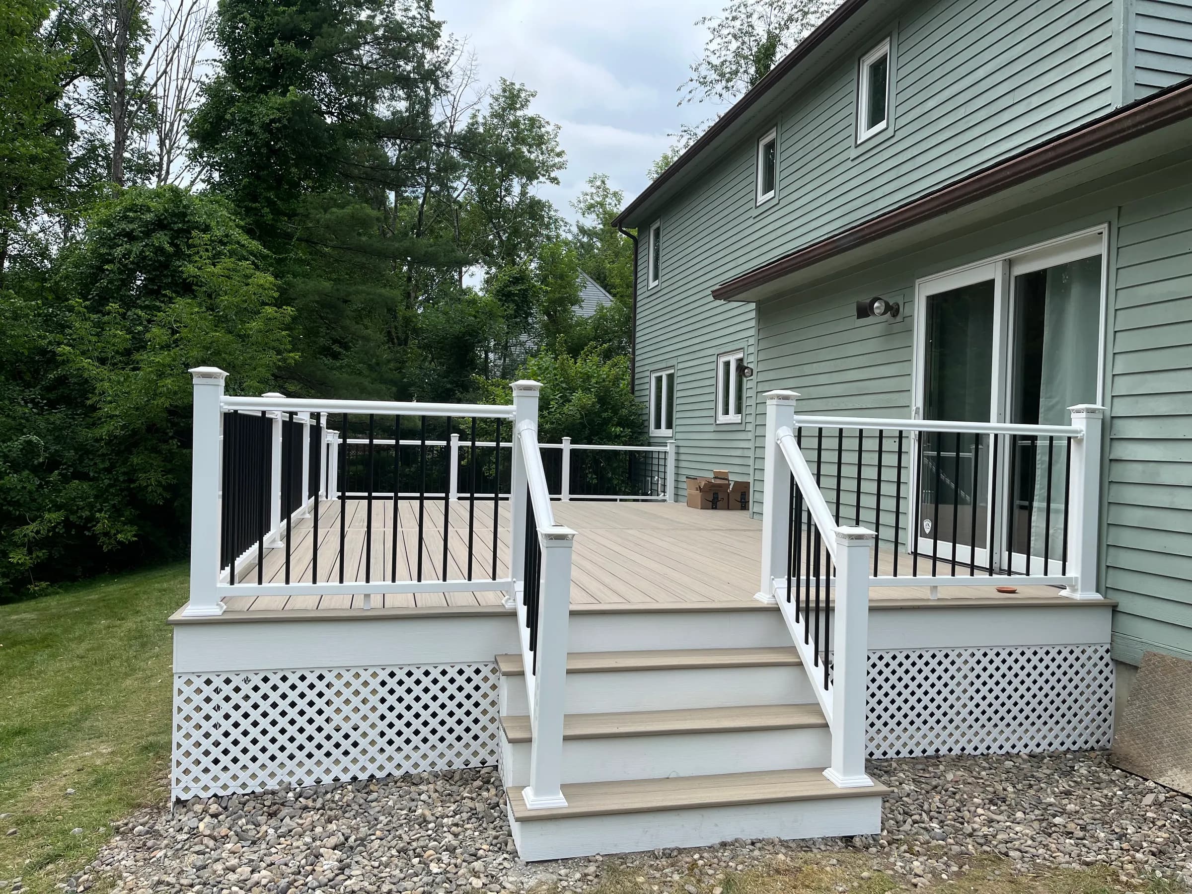 Composite deck beside sage green house
