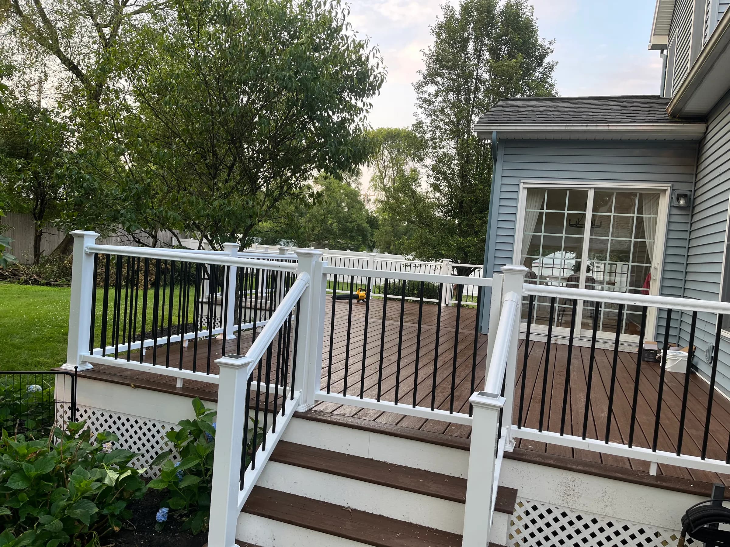 Brown deck with white pergola and railings
